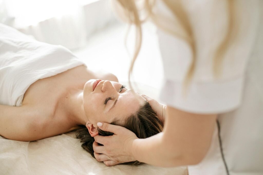 A woman receiving a calming head massage at a spa, promoting relaxation and wellness.